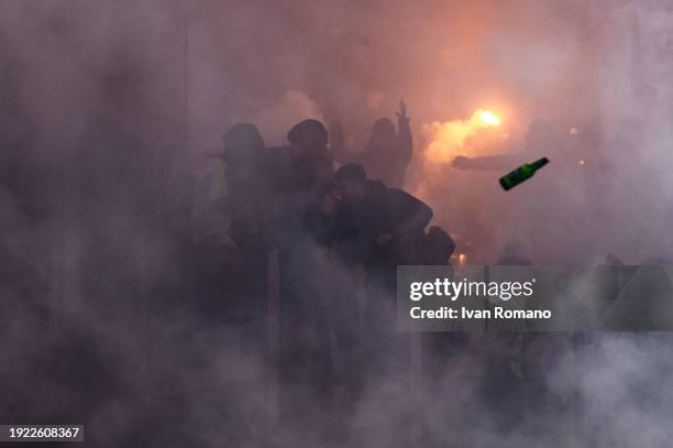 Smoke bombs and firecrackers are thrown between supporters of SS Lazio and AC Roma before the Coppa Italia quarter-finals match between SS Lazio and...