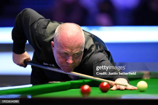 John Higgins of Scotland plays a shot during his first round match against Mark Allen of England on day four of the MrQ Masters Snooker 2024 at...