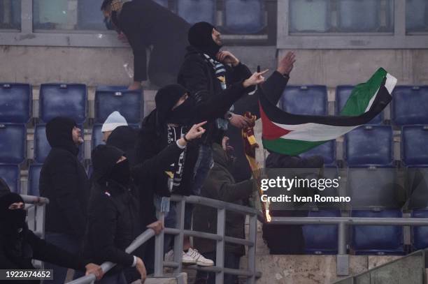 An SS Lazio fan with an AS Roma scarf on fire during the Coppa Italia quarter-finals match between SS Lazio and AS Roma at Stadio Olimpico on January...