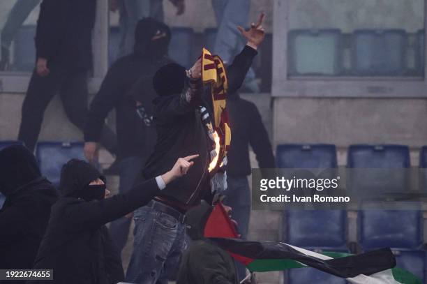 An SS Lazio fan with an AS Roma scarf on fire during the Coppa Italia quarter-finals match between SS Lazio and AS Roma at Stadio Olimpico on January...