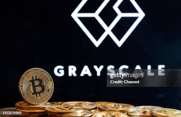 In this photo illustration, a visual representation of the digital cryptocurrency Bitcoin is displayed in front of the logo of the US digital...