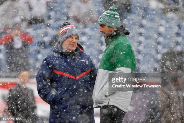 Head coach Bill Belichick of the New England Patriots talks with Aaron Rodgers of the New York Jets at Gillette Stadium on January 7, 2024 in...