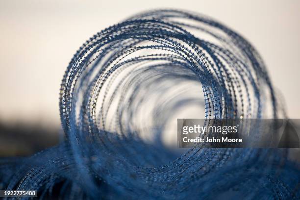 Coils of razor wire installed by the Texas National Guard run along the U.S.-Mexico border on January 10, 2024 in Eagle Pass, Texas. Following a...