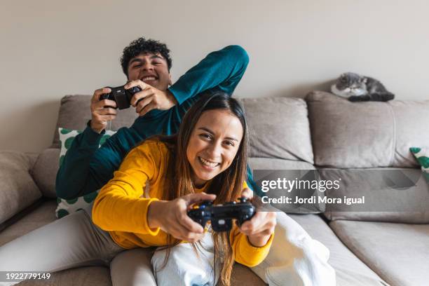 engaging in a video game session in a cozy home setting - joueur de jeux informatiques photos et images de collection