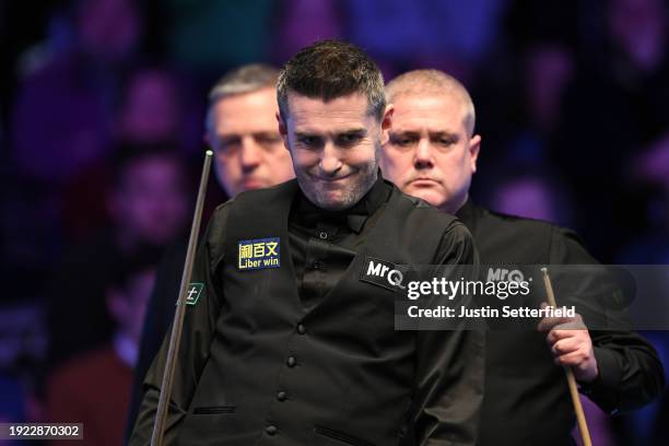 Mark Selby of England and opponent Robert Milkins of England look on during their first round match against Robert Milkins of England during day four...