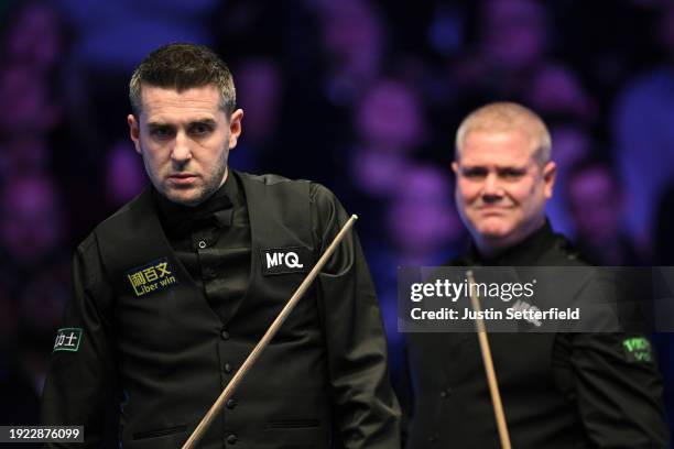 Mark Selby of England and opponent Robert Milkins of England look on during their first round match against Robert Milkins of England during day four...