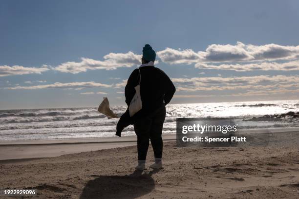 Woman walks along the beach at Rockaway during heavy surf following a storm that brought high winds and rain to the area on January 10, 2024 in New...