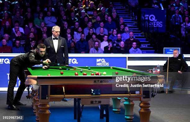 Mark Selby of England plays a shot with the rest in his first round match against Robert Milkins of England during day four of the MrQ Masters...