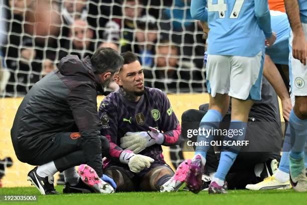 Manchester City's Brazilian goalkeeper Ederson receives a second period of medical attention during the English Premier League football match between...