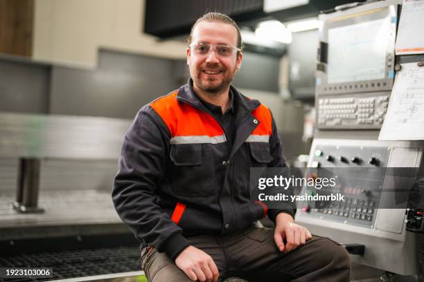 portrait d’un jeune technicien debout devant une machine cnc dans l’industrie. - manual worker milling machine operator photos et images de collection