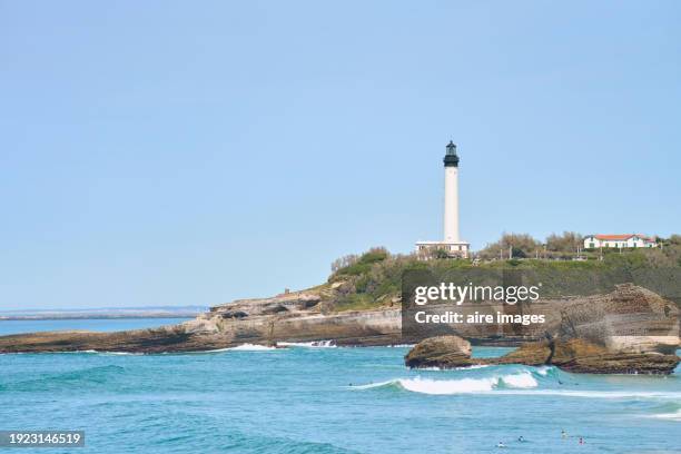 coastal lighthouse stands to protect the ocean and guide the voyage of navigators. - baskenland stock-fotos und bilder