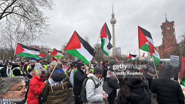 People, holding banners and Palestinian flags, gather in front of Alexanderplatz Square and march from German Federal Foreign Office to Potsdamer...