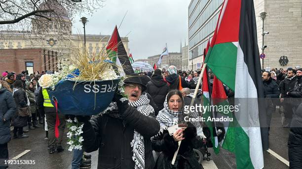People, holding banners and Palestinian flags, gather in front of Alexanderplatz Square and march from German Federal Foreign Office to Potsdamer...