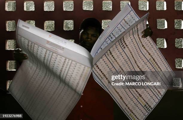 Congolese voter consults his ballot paper 30 July 2006 in a polling station in the Bandalungwa district of Kinshasa, DRCongo. Millions of voters in...