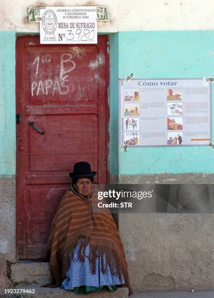 Una mujer indigena miembro del jurado electoral, controla la puerta del recinto en donde ingresan los votantes para marcar las papeletas, en un...