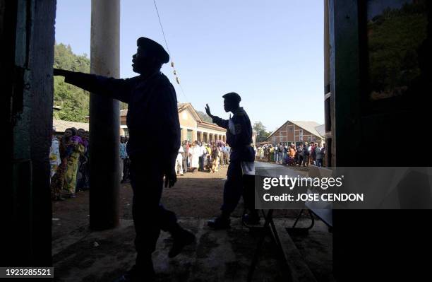 Congolese policemen try to put order as people queue outside a polling station in Bukavu 18 December 2005. Polls opened early Sunday in the...