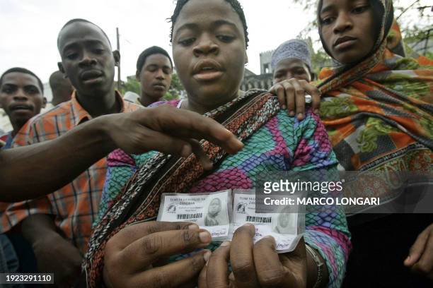 Supporters of the opposition Civic United Front shows two electoral cards confiscated from the same woman who attempted to vote 30 October 2005 in...