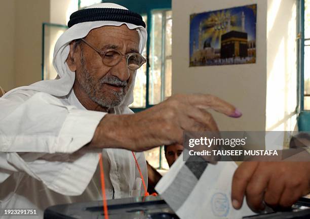 An Iraqi man casts his vote at polling station during a referendum on a new constitution of Iraq in Saddam's hometown of Tikrit, 15 October 2005....