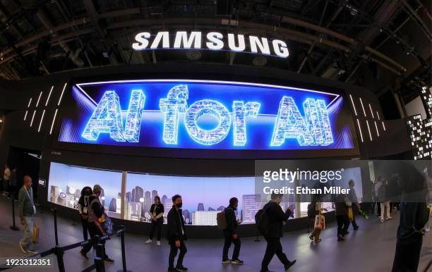 Attendees enter the Samsung booth as a digital message "AI for All" is displayed during CES 2024 at the Las Vegas Convention Center on January 10,...