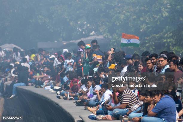 People watching as the Indian Air force Surya Kiran aerobatics team, Sarang helicopter team and Sukhoi aircraft perform during Air Show 2024 at...