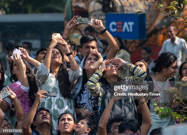 People watching as the Indian Air force Surya Kiran aerobatics team, Sarang helicopter team and Sukhoi aircraft perform during Air Show 2024 at...