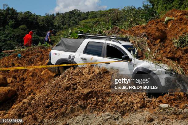 View of a wrecked car at the area of a landslide in the road between Quibdo and Medellin, Choco department, Colombia on January 13, 2024. At least 33...