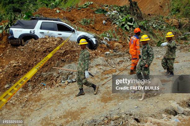 Members of the rescue team walk near the zone of a landslide in the road between Quibdo and Medellin, Choco department, Colombia on January 13, 2024....