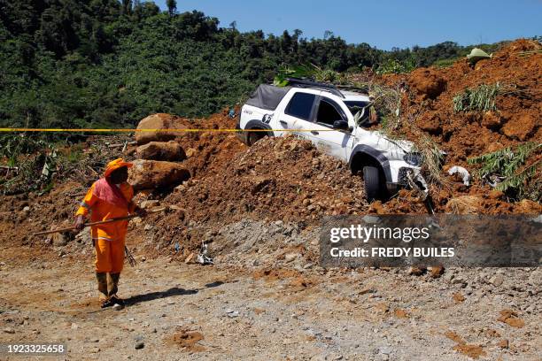 Member of the rescue team stands at the area of a landslide in the road between Quibdo and Medellin, Choco department, Colombia on January 13, 2024....