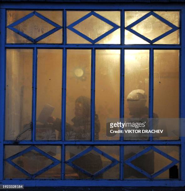 Picture taken through a window shows a woman casting her ballot, as the members of a local electoral commission brought a mobile ballot box in the...