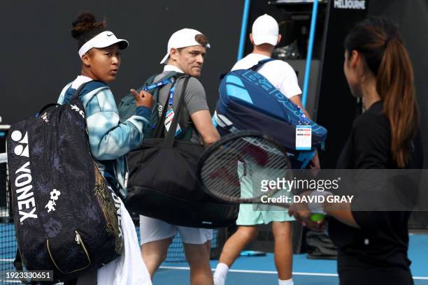Japan's Naomi Osaka talks to Britain's Emma Raducanu after a practice session on day one of the Australian Open tennis tournament in Melbourne on...