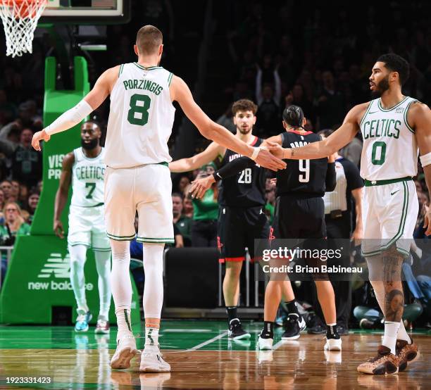 Kristaps Porzingis high-fives Jayson Tatum of the Boston Celtics during the game against the Houston Rockets on January 13, 2024 at the TD Garden in...