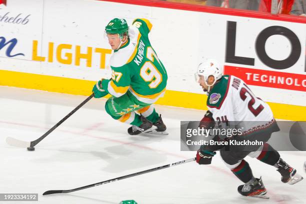 Kirill Kaprizov of the Minnesota Wild skates with the puck while Matt Dumba of the Arizona Coyotes defends during the game at the Xcel Energy Center...