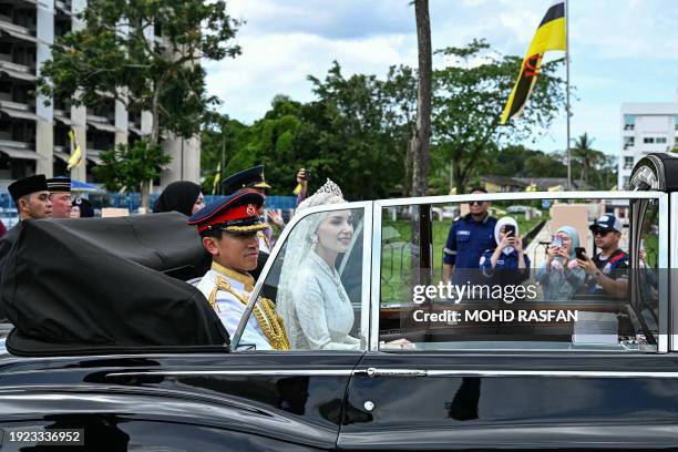 Prince Abdul Mateen and Yang Mulia Anisha Rosnah sit in their car during the wedding procession in Brunei's capital Bandar Seri Begawan on January...