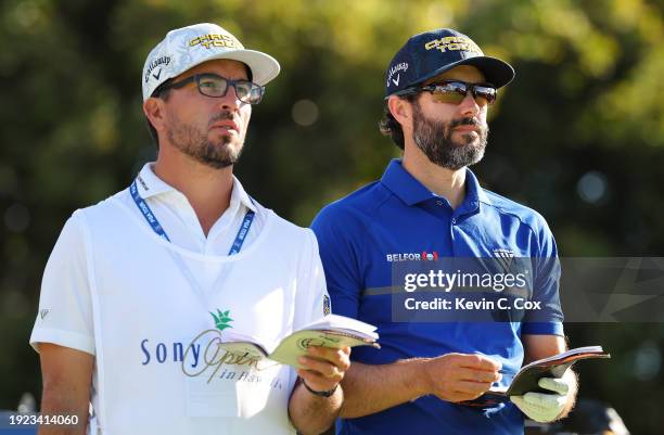 Adam Hadwin of Canada coverses with his caddie on the 16th tee during a pro-am prior to the Sony Open in Hawaii at Waialae Country Club on January...