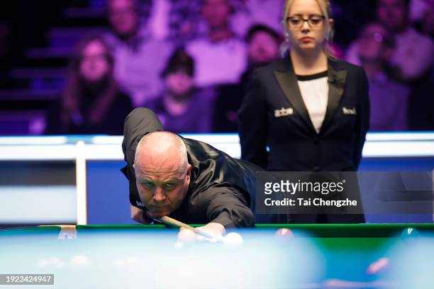 John Higgins of Scotland plays a shot in the first round match against Mark Allen of Northern Ireland on day 4 of the 2024 MrQ Masters Snooker at...