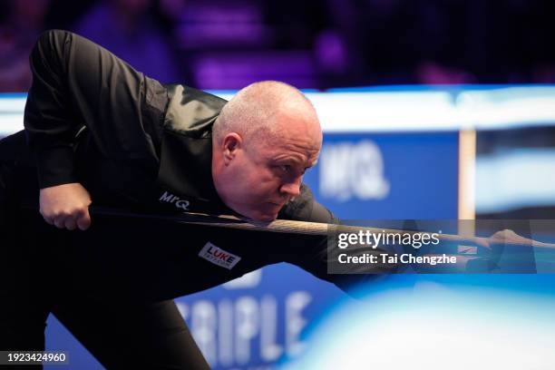 John Higgins of Scotland plays a shot in the first round match against Mark Allen of Northern Ireland on day 4 of the 2024 MrQ Masters Snooker at...