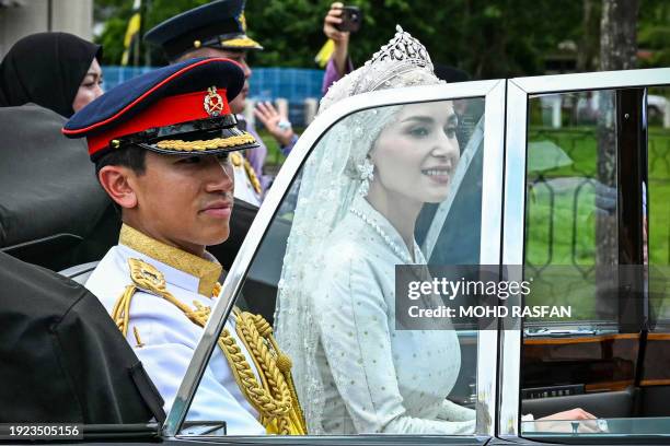 Prince Abdul Mateen and Yang Mulia Anisha Rosnah are seen in their car during their wedding procession in Brunei's capital Bandar Seri Begawan on...