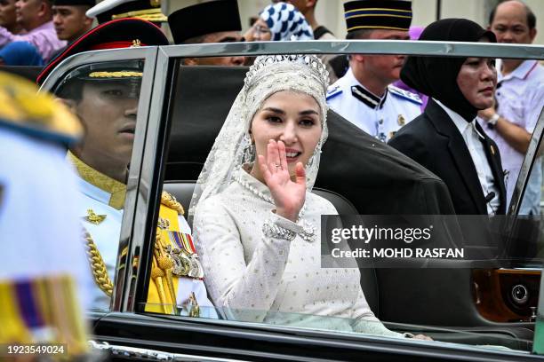 Prince Abdul Mateen and Yang Mulia Anisha Rosnah are seen in their car during their wedding procession in Brunei's capital Bandar Seri Begawan on...