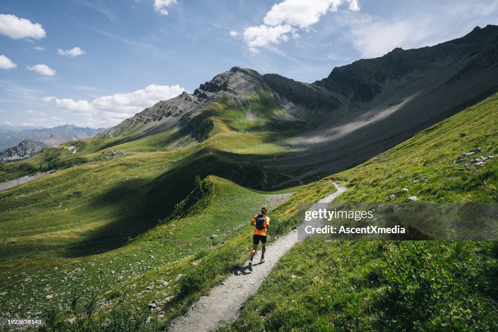 Trail runner bounds along mountain trail