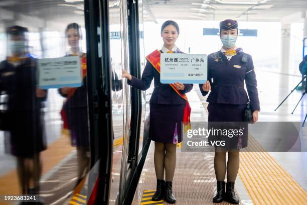 Staff members celebrate the launch of a new bullet train service heading directly for Guangzhou East Railway Station in south China's Guangdong...