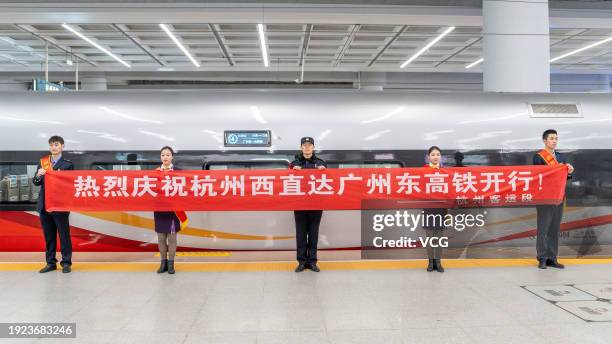 Staff members celebrate the launch of a new bullet train service heading directly for Guangzhou East Railway Station in south China's Guangdong...