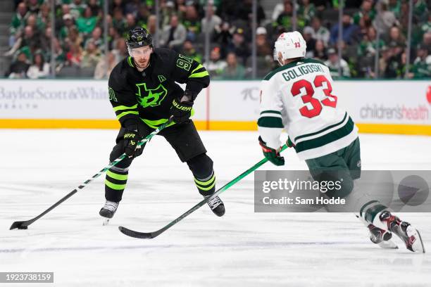 Tyler Seguin of the Dallas Stars skates the puck against Alex Goligoski of the Minnesota Wild during the third period at American Airlines Center on...