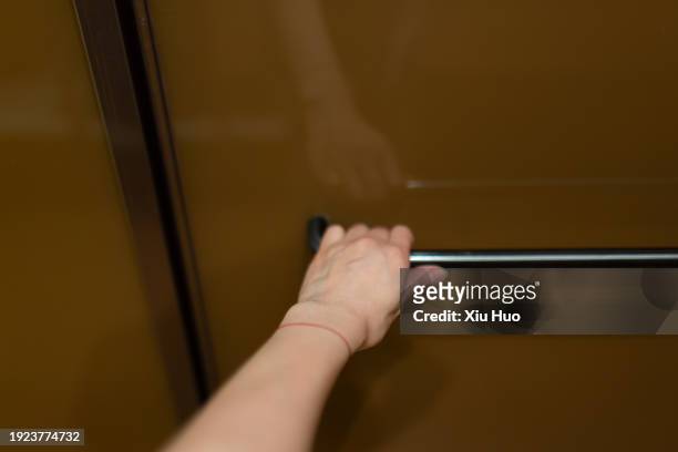 one hand is pushing open the bathroom door. - draft period closes stock pictures, royalty-free photos & images
