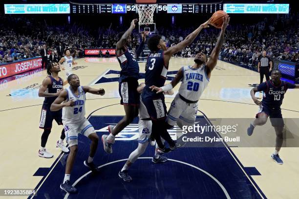 Dayvion McKnight of the Xavier Musketeers attempts a shot while being guarded by Jaylin Stewart of the Connecticut Huskies in the second half at...
