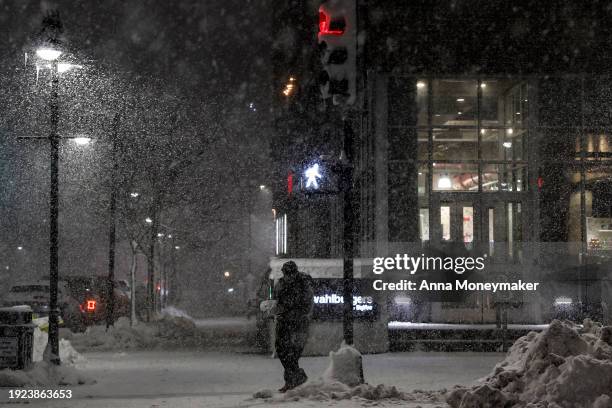 People walk in the streets of downtown Des Moines during a snow squall on January 10, 2024 in Des Moines, Iowa. Republican presidential candidates...