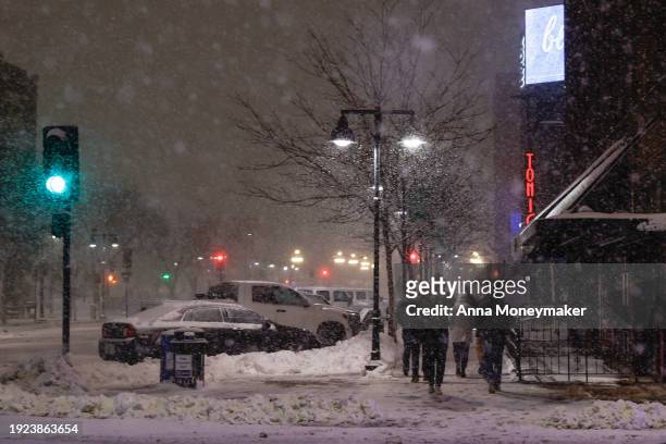 People walk in the streets of downtown Des Moines during a snow squall on January 10, 2024 in Des Moines, Iowa. Republican presidential candidates...