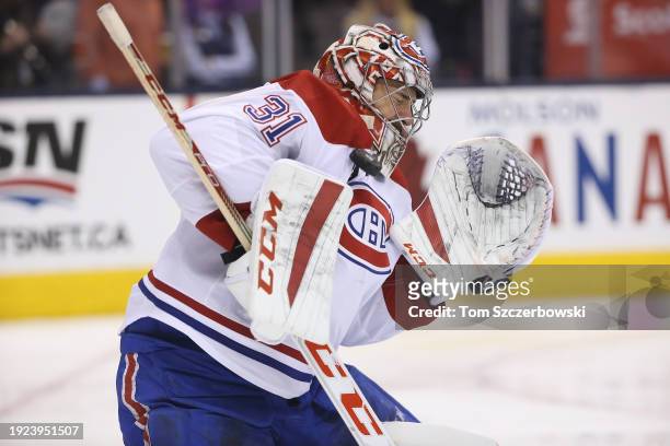 Carey Price of the Montreal Canadiens makes a save as he stops the puck with his shoulder during NHL game action against the Toronto Maple Leafs at...