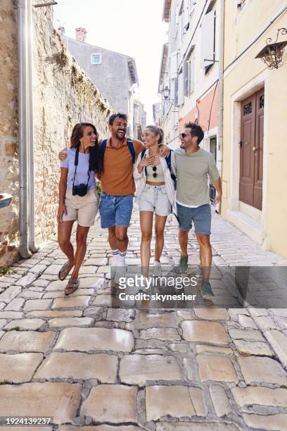 cheerful tourists having fun while walking on the street. - rovinj stock pictures, royalty-free photos & images