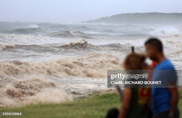 Members of the public take photos at the seafront ahead of cyclone Belal expected to hit the region, in Saint-Denis, on the French Indian Ocean...