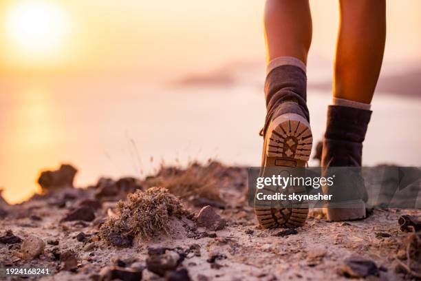 hiker on a hill above the sea at sunset! - walking boot stock pictures, royalty-free photos & images
